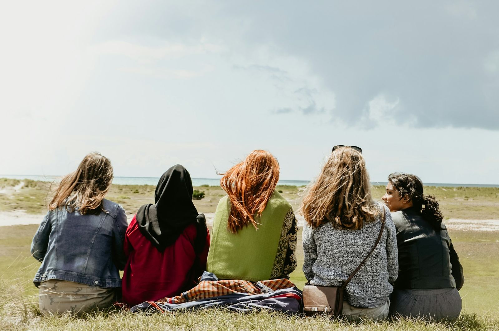 A group of women sitting together on the grass
